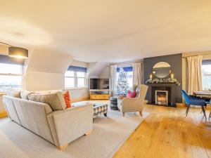 a living room with a couch and a fireplace at Hill View in Dalbeattie