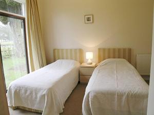 twee bedden in een kleine kamer met een raam bij The Gatehouse in Hooke