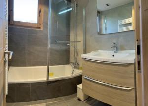 a bathroom with a tub and a sink and a shower at CHALET LA LICORNE 1 - pied des pistes in Notre-Dame-de-Bellecombe +35 photos