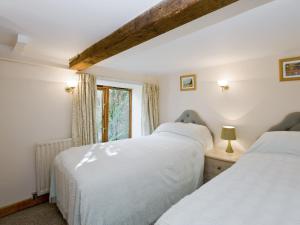 two beds in a room with a window at Malt Shovel in Dilham