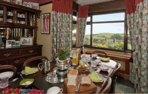 Tregondale Manor Farm في ليسكيرد: غرفة طعام مع طاولة ونافذة كبيرة
