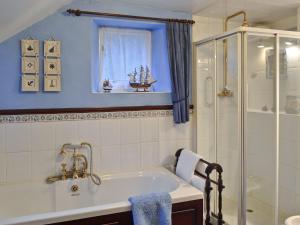 uma casa de banho com banheira e chuveiro em Toms Cottage em Dalton in Furness