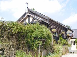 an old house with ivy on the side of it at Hirros Hall Longhouse in Llanerfyl