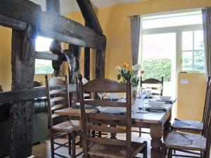 a dining room with a wooden table and chairs at Hirros Hall Longhouse in Llanerfyl