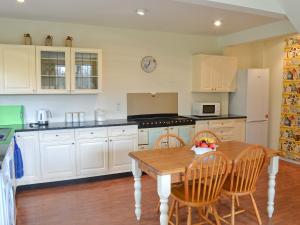 eine Küche mit einem Holztisch und Stühlen in der Unterkunft Heron Cottage in Timsbury