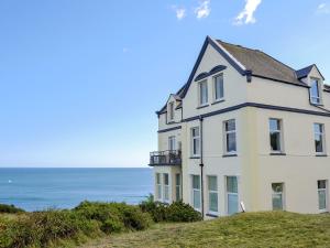 a house on a hill with the ocean in the background at Spindrift in Coverack