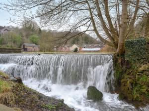 einem Wasserfall an der Flussseite in der Unterkunft Mill Pond Cottage in Cromford