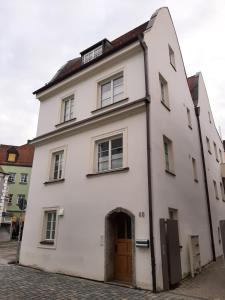 a white building with a door on a street at Zentrale Lage I historisch I Parkplatz I Fahrradkeller in Straubing