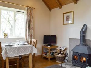 a living room with a table and a stove at The Bullpen in Skenfrith