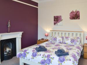 a bedroom with a bed with towels and a fireplace at Bay House in Filey