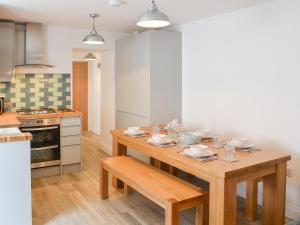 a kitchen with a wooden table with dishes on it at Rosetta Apartments - Ocean Mist in Newquay