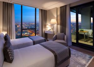 two beds in a hotel room with a view at Movenpick Living Istanbul West in Istanbul
