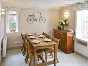 a dining room with a table and a bike on the wall at Poppies in Blakeney