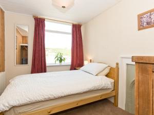 a bedroom with a bed and a window at Tinakori in Staithes