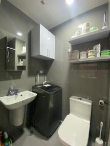 bagno con servizi igienici bianchi e lavandino di Air Residences 4439 a Manila