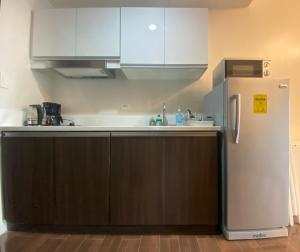 una cucina con armadietti bianchi e frigorifero di Air Residences 4439 a Manila