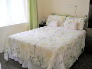 een slaapkamer met een bed met een wit dekbed bij Wrens Nest in Llanfair Caereinion
