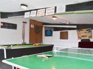 a ping pong table in a room with a pool table at Wrens Nest in Llanfair Caereinion