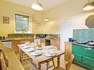 a kitchen with a table with plates on it at Lochside Stable Hse in Town Yetholm