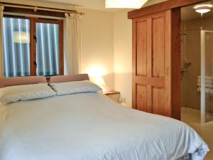 een slaapkamer met een groot wit bed en een raam bij Torridge in Great Torrington
