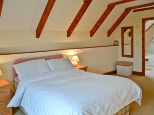 Un dormitorio con una gran cama blanca y una ventana en Torridge en Great Torrington