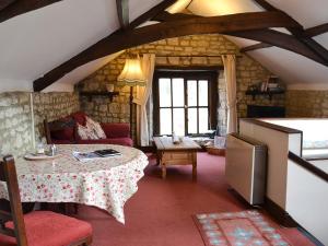 a living room with a table and a couch at Weycroft Hall Cottage in Axminster