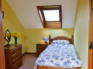 a bedroom with a bed and a window and a dresser at Owl Barn in Burmarsh