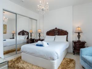 a bedroom with a large white bed and a mirror at Babbacombe Bay, Torquay in Torquay