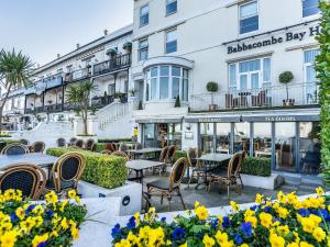 a restaurant with tables and chairs in front of a building at Babbacombe Bay, Torquay in Torquay
