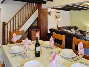 a dining room with a table with a bottle of wine at Capel Fawnog Mawr in Talsarnau