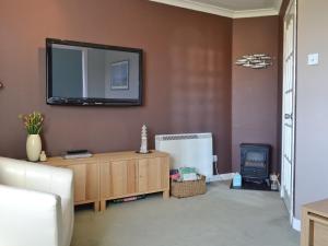 a living room with a tv on the wall at Seaview Repose in Leurbost