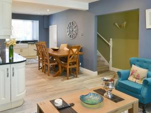 cocina y sala de estar con mesa y sillas en Littlecroft, en Alnmouth