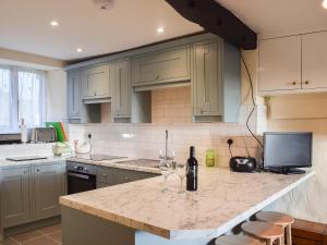 a kitchen with a counter with two wine glasses on it at Oak Cottage in Ambleside