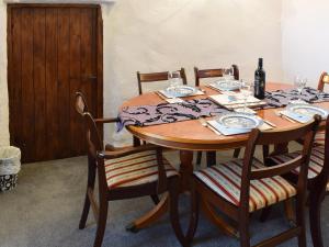 a wooden table with chairs and wine glasses on it at Oak Cottage in Ambleside