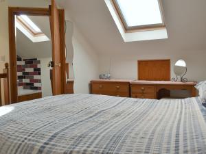 a bedroom with a large bed and skylights at Biskey Howe Cottage in Bowness-on-Windermere