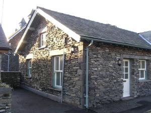 a stone house with a pitched roof at Biskey Howe Cottage in Bowness-on-Windermere