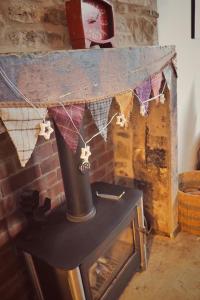 a brick fireplace with a stove with a clock on it at Woodworth Cottage in Barnoldswick