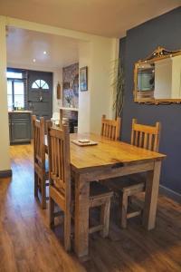 uma mesa de jantar em madeira com cadeiras e um espelho em Woodworth Cottage em Barnoldswick