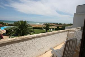a balcony with chairs and a view of the ocean at Residence Club Barbara in Ostuni
