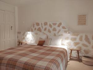 1 dormitorio con 1 cama grande con manta a cuadros en Domaine l'Oiseau Bleu, en Sainte-Maxime