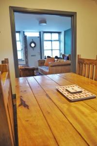 Habitación con mesa de madera y sala de estar. en Woodworth Cottage, en Barnoldswick