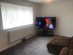 a living room with a flat screen tv in a room with a window at High rd hideaway in Warmsworth