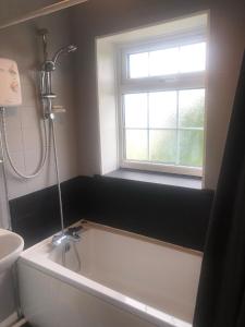 a bathroom with a bath tub and a window at High rd hideaway in Warmsworth