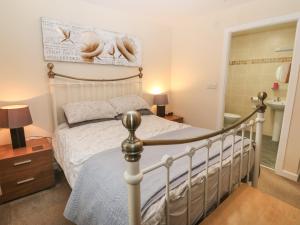 a bedroom with a bed and a bathroom at Beach View in Benllech