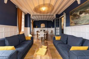 a living room with a blue couch and a table at Le Manoir des EMBRUNS 14P - Location N1- Terrace- public parking 2 min in Honfleur
