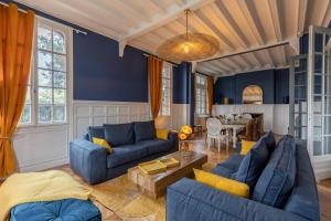 een woonkamer met blauwe banken en een tafel bij Le Manoir des EMBRUNS 14P - Location N1- Terrace- public parking 2 min in Honfleur
