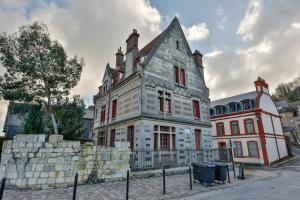 stary dom z kamienną ścianą przed nim w obiekcie Le Manoir des EMBRUNS 14P - Location N1- Terrace- public parking 2 min w mieście Honfleur