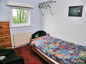 a bedroom with a bed and a window at Drumlin in Hawkshead