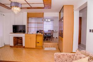 a living room with a fireplace and a dining room at Hope Homestay in Syokimau