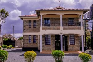 a large brick house with a balcony at Hope Homestay in Syokimau